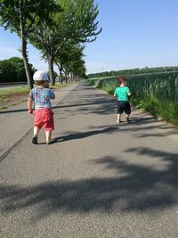 Rear view of boy walking with umbrella