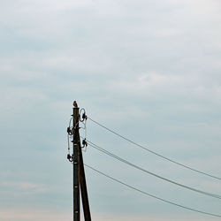 Low angle view of electricity pylon against sky