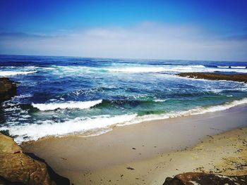 Scenic view of beach against blue sky