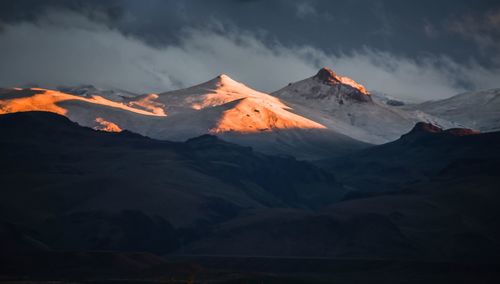 Scenic view of snowcapped mountains against sky during sunset