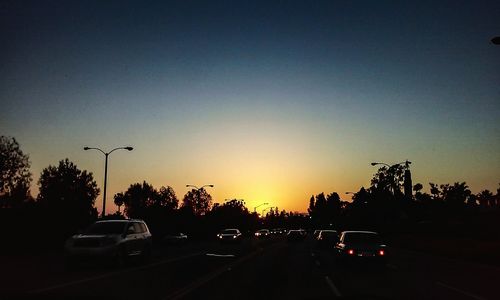 Traffic on road at sunset