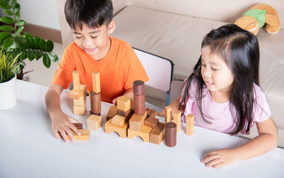 Portrait of siblings playing with toy blocks