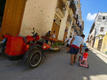 People on street amidst buildings in city