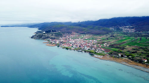 High angle view of buildings by sea against sky