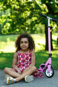 Portrait of young woman sitting on field