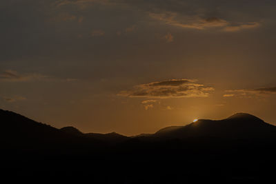 Scenic view of silhouette mountains against sky during sunset