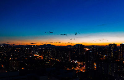 Illuminated buildings in city against sky at night