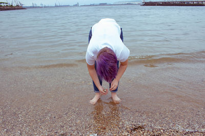 Rear view of woman standing at beach