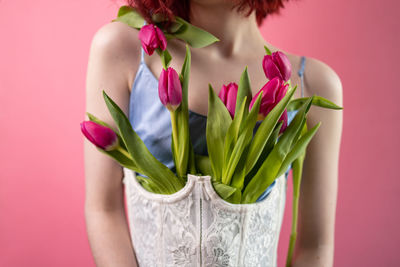 Midsection of woman holding flowers