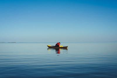 Man on boat in sea against sky