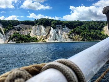 Close-up of rocks by river against sky