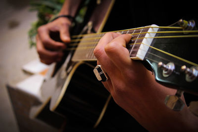 Cropped hands of man playing guitar