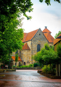 Exterior of historic building by trees against sky