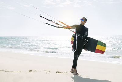 Man skateboarding on beach against sky