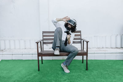 Side view of man sitting on bench