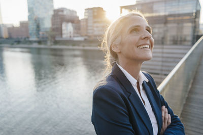 Smiling businesswoman on bridge looking up