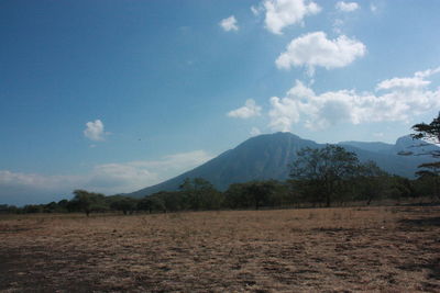 Scenic view of land and mountains against sky