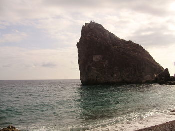 Scenic view of rock and sea against sky