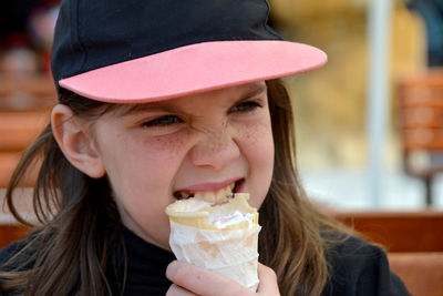 Close up image of girl hand holding fresh waffle cone with vanilla