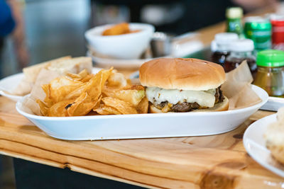 Delicious meal burger with fries white plate. healthy meat burger food on wooden table background.