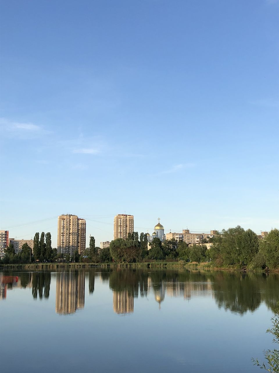 REFLECTION OF BUILDINGS IN LAKE AGAINST SKY