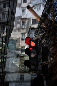 Low angle view of road signal against buildings in city