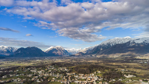 Aerial view of townscape and mountains against sky