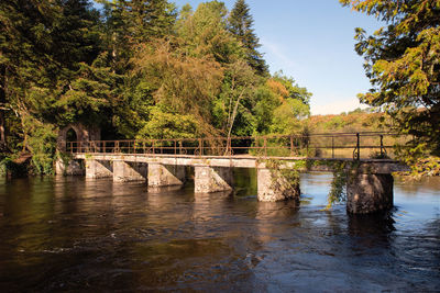 Arch bridge over river against sky