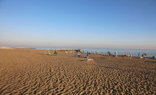 Group of people on beach against clear sky