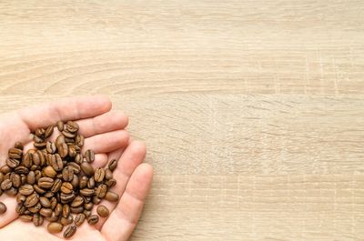 Close-up of hand holding coffee beans