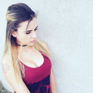 Close-up of beautiful woman standing by wall