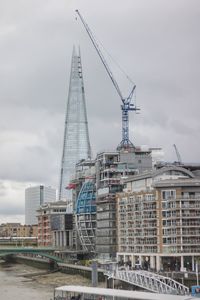 Crane at construction site against sky