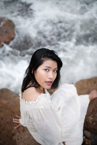 Portrait of young woman standing at beach