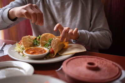 Midsection of man holding food on table