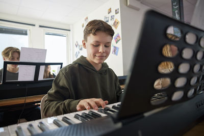 Teenagers attending keyboard lesson