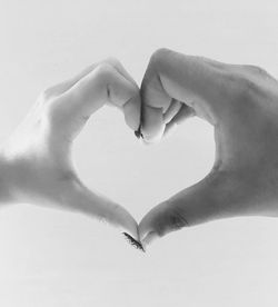 Couple making heart shape over white background