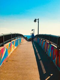 Street lights on bridge against sky