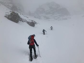 People walking on snow covered land during winter