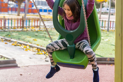 Girl sitting on swing at park