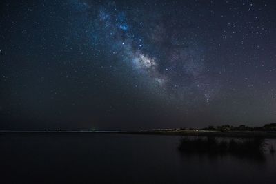 Scenic view of lake against sky at night