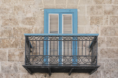 Typical balcony in cuban baroque style in old havana,cuba. wrought railings, door with wooden blinds