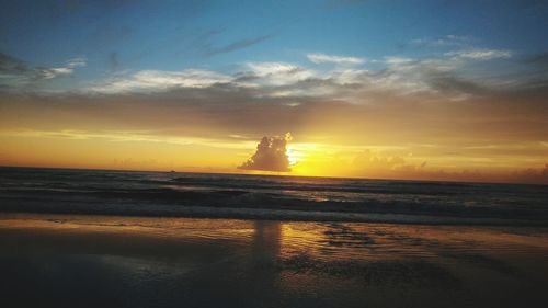 Silhouette of lighthouse at beach during sunset