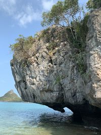 Rock formation by sea against sky