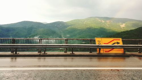 Bridge over mountain against sky