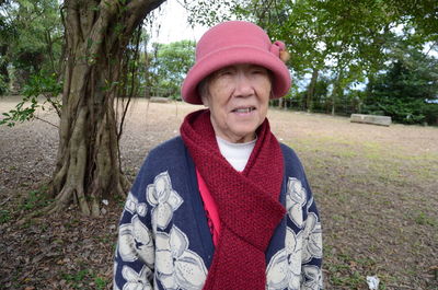 Senior woman wearing warm clothing standing at public park