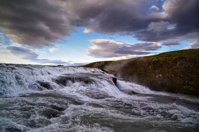 Scenic view of waterfall against sky