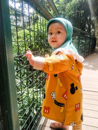 Cute boy looking away while standing outdoors