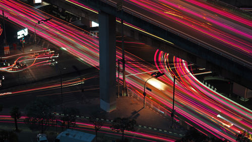 Busy main road intersection in city arear with car and motorcycle blurred light trails.