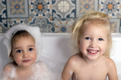 Portrait of girls sitting in bathtub