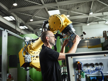 Engineer working in industry with robotic machine